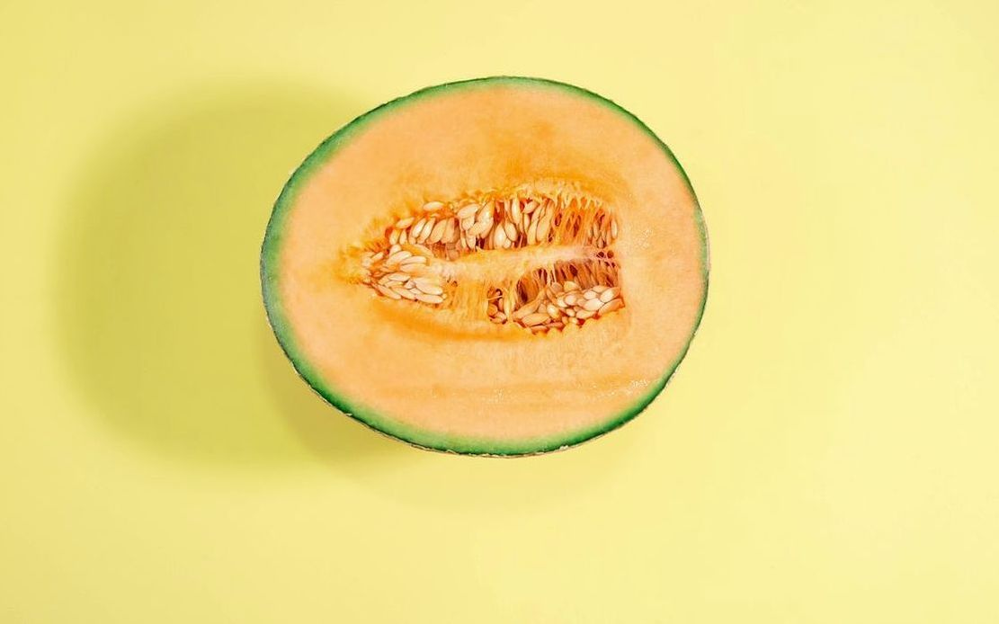 Cam bardakta buzlu mango smoothie, üstünde granola ve bal